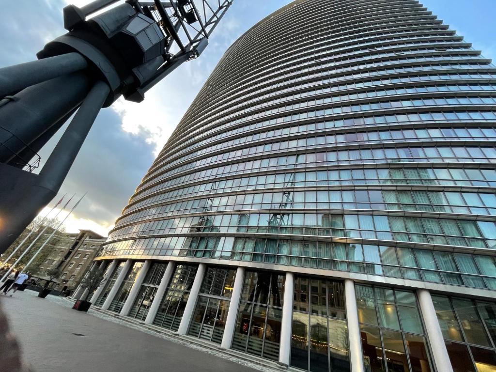 a tall office building with a lot of windows at Stunning View 2 Bed Apartment - Canary Wharf City in London