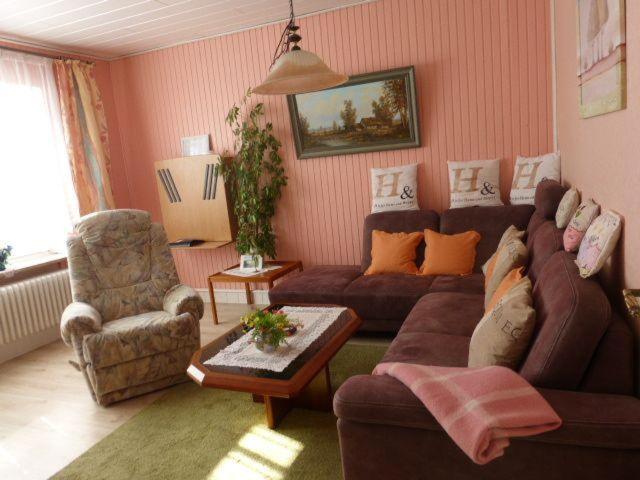 ein Wohnzimmer mit einem Sofa und einem Stuhl in der Unterkunft Ferienwohnnung Westerwarft in Büsum