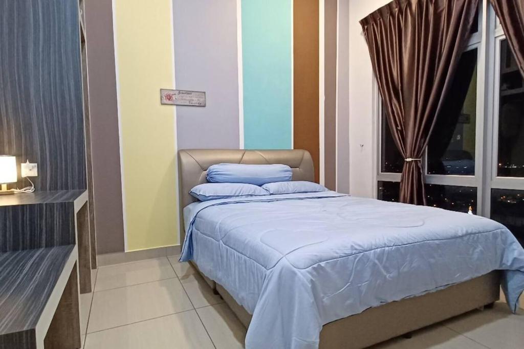 1 dormitorio con cama con sábanas azules y ventana en Paradise Sovo Austin Height, en Johor Bahru