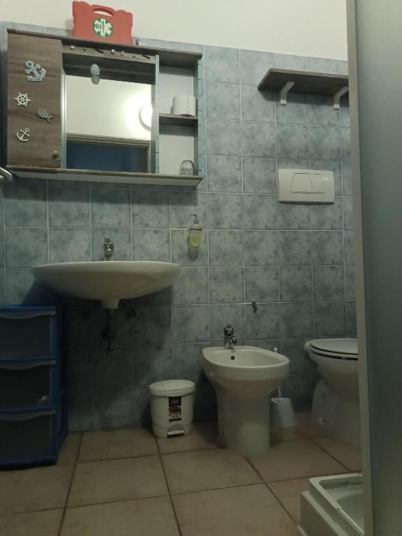 łazienka z umywalką, toaletą i lustrem w obiekcie Bibbona Summer - Pineta 1 - w mieście Marina di Bibbona