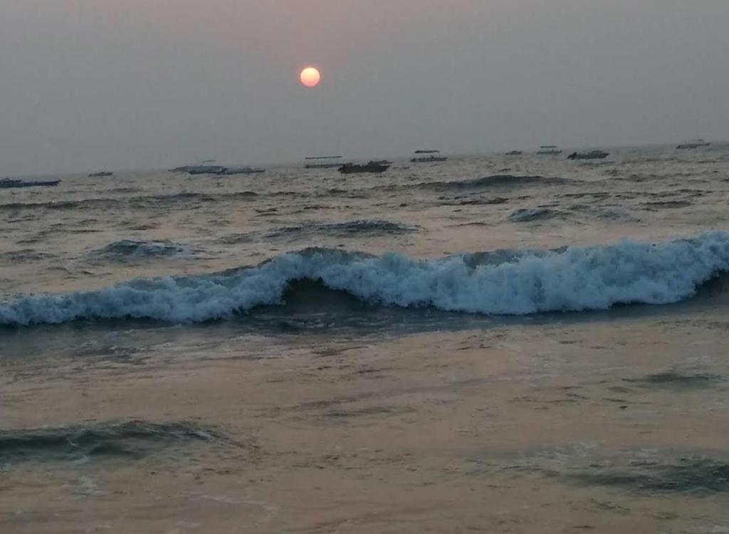una ola en el océano con el sol en el fondo en De Ocean High touch, en Pūrnānkuppam