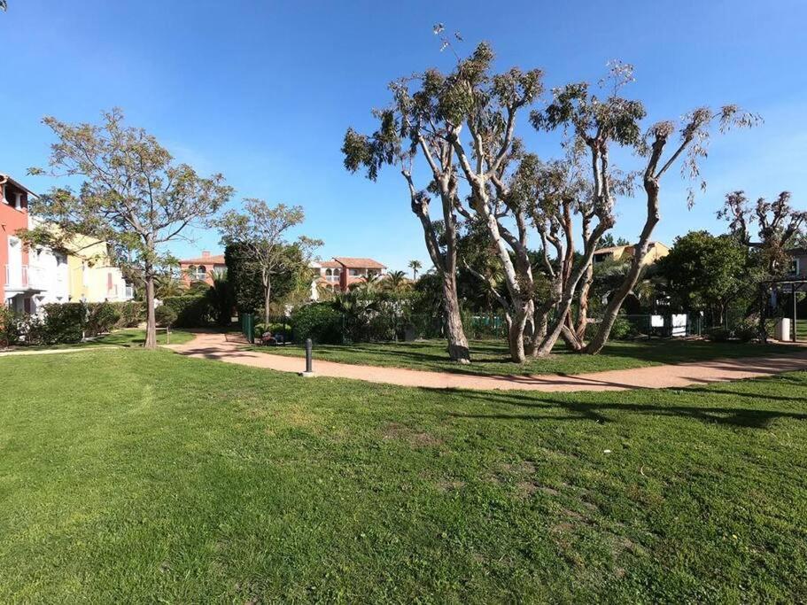 a park with green grass and trees and a sidewalk at Presqu&#39;ile de Giens - Hameau de la Pinede in Hyères