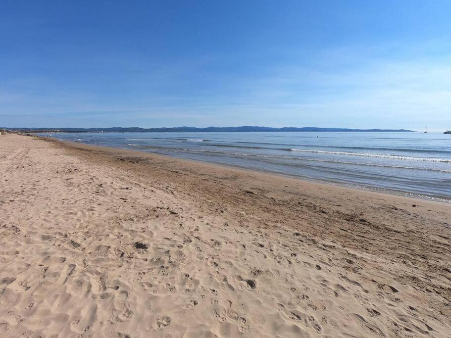 a beach with footprints in the sand and the ocean at Presqu&#39;ile de Giens - Hameau de la Pinede in Hyères