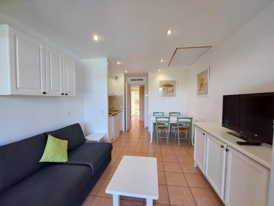 a living room with a blue couch and a kitchen at Presqu&#39;ile de Giens - Hameau de la Pinede in Hyères