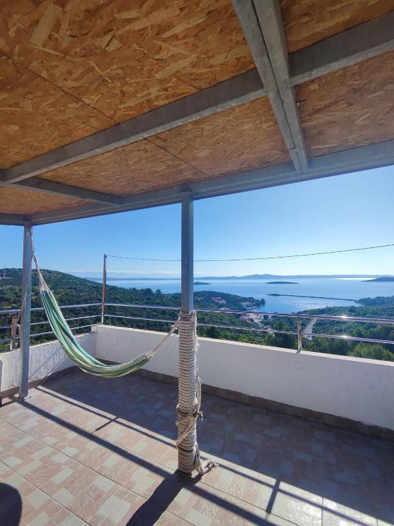 un balcón con hamaca y vistas al océano en Lavander House, en Sali