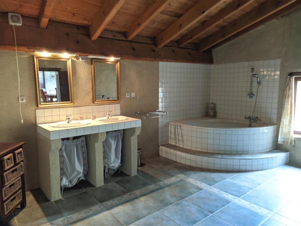 een badkamer met 2 wastafels en een bad bij Gite Le Chevalier in La Répara