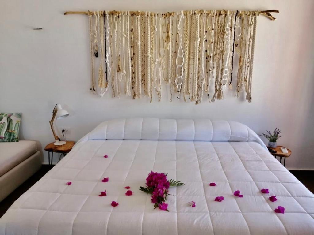 a bedroom with a white bed with flowers on it at VILLA DEL CIELO TIXPEHUAL in Tixpehual