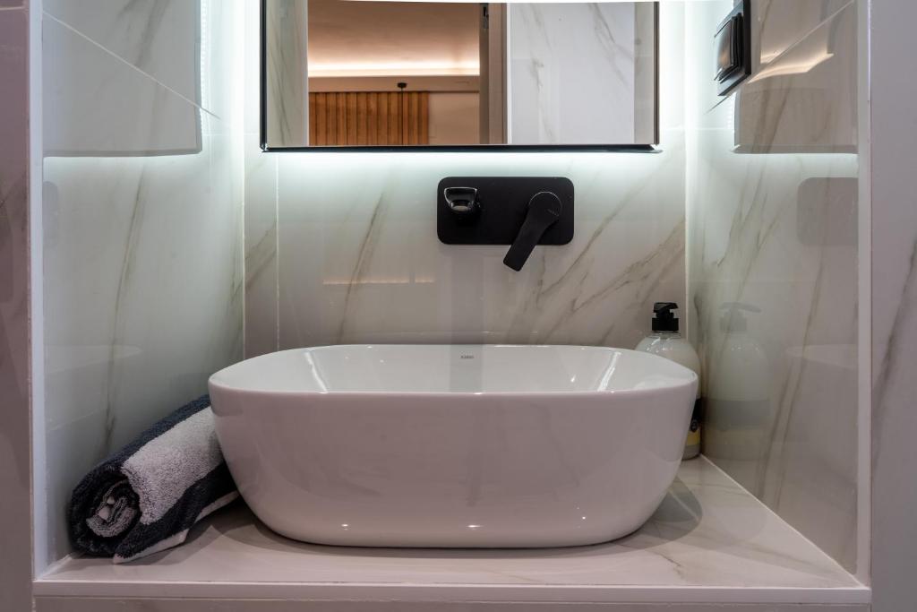 a white sink in a bathroom with a mirror at NERO SEASCAPE SUITES in Fanari