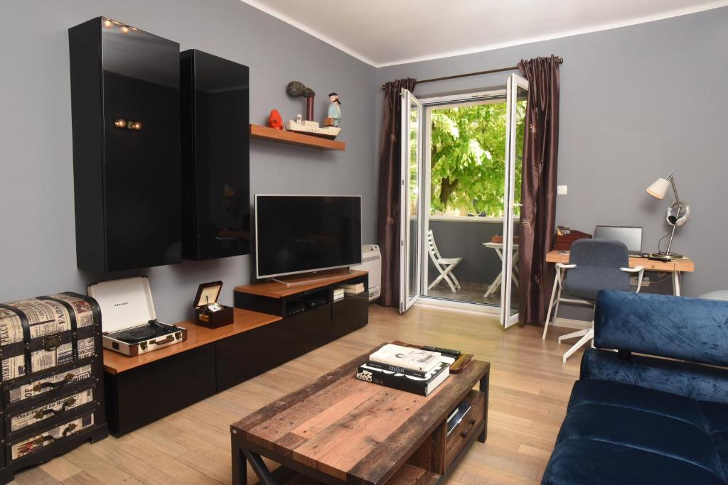 uma sala de estar com um sofá azul e uma televisão em Apartment Toro em Split