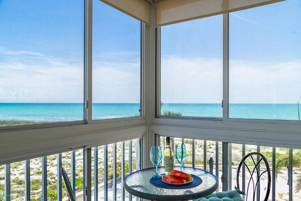 a dining room with windows looking out at the beach at San Marco Gulf Beach Views 3rd Floor in Venice
