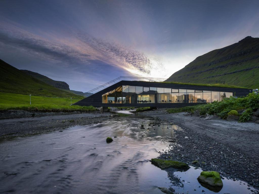 a building in the middle of a river at Experience unique Faroe Islands holiday home by the sea with great views, fully equipped kitchen and reliable Wi-Fi 