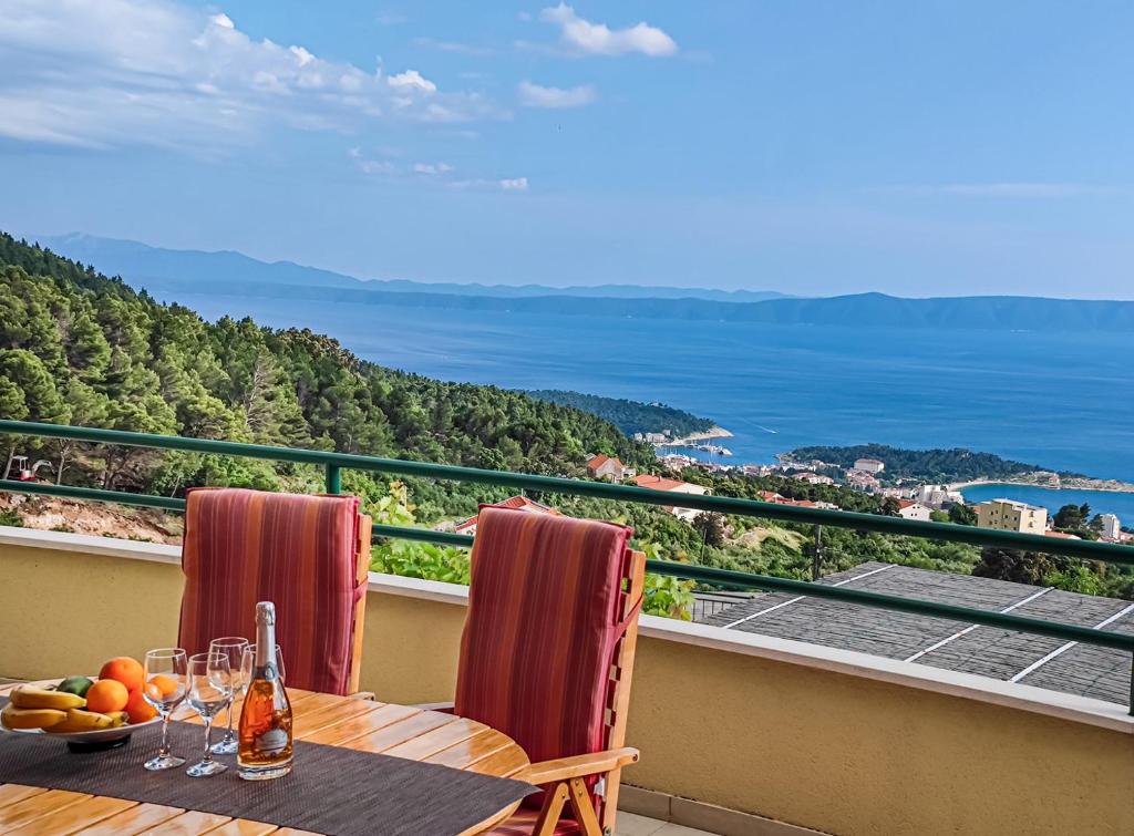 a table on a balcony with a view of the ocean at Villa Marino in Makarska, private pool in Makarska