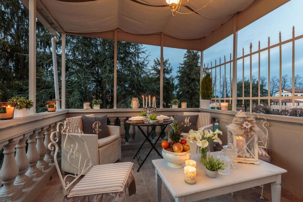a porch with chairs and a table with fruits and candles at CASA UCCELLINI with a Romantic Terrace in Lucca