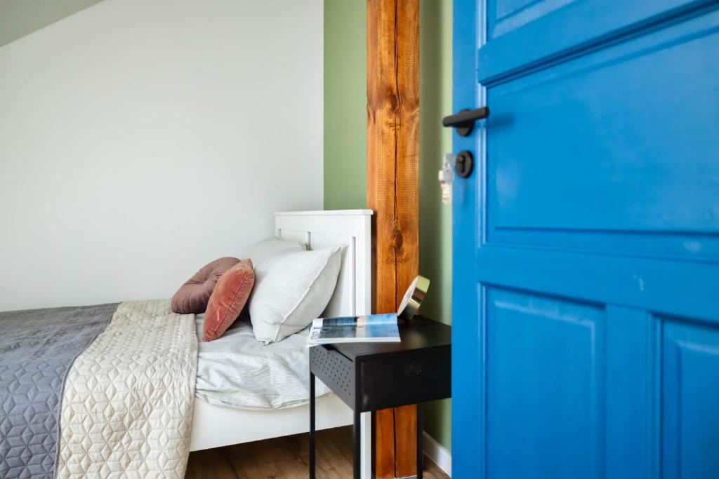 um quarto com uma cama e uma porta azul em Apartament na Jezuickiej em Lublin