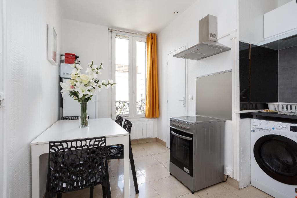a kitchen with a table with a vase of flowers on it at F1 Jean Jaurès 3G in Aubervilliers