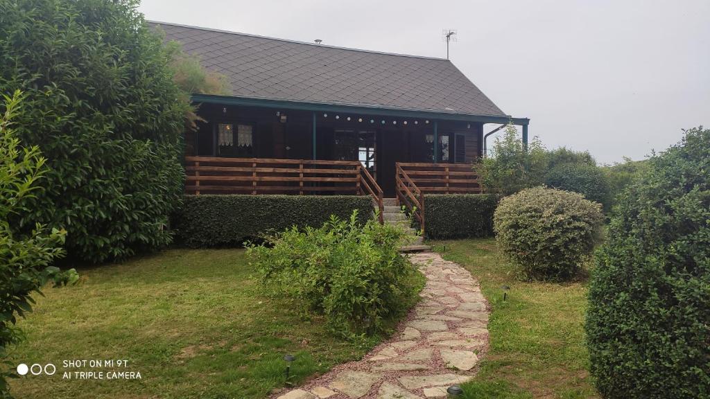 a house with a porch and a stone path in front of it at Le petit chalet in Gapennes