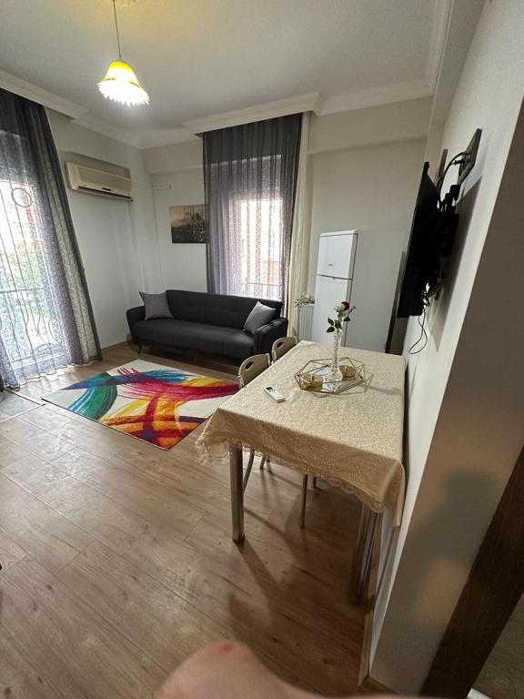 ein Wohnzimmer mit einem Tisch und einem Sofa in der Unterkunft فندق الصقر الذهبي in Pelitli