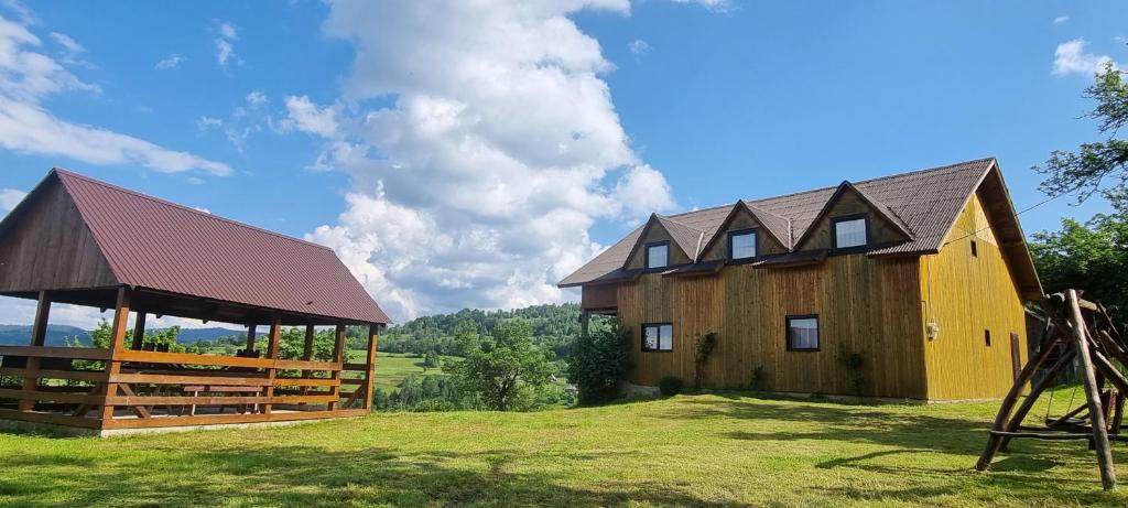 un fienile con gazebo e una casa di Cabana Suciu a Răchiţele