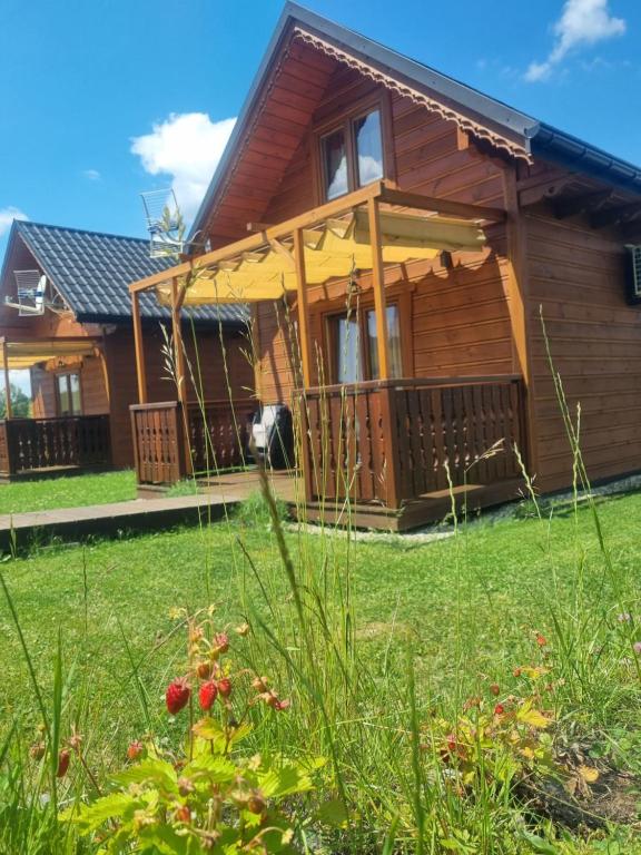 una casa con terraza y patio en Domki na Zagroniu, en Koninki