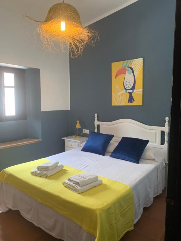 a bedroom with a bed with blue walls and a yellow blanket at Molino El Mastral in Tarifa