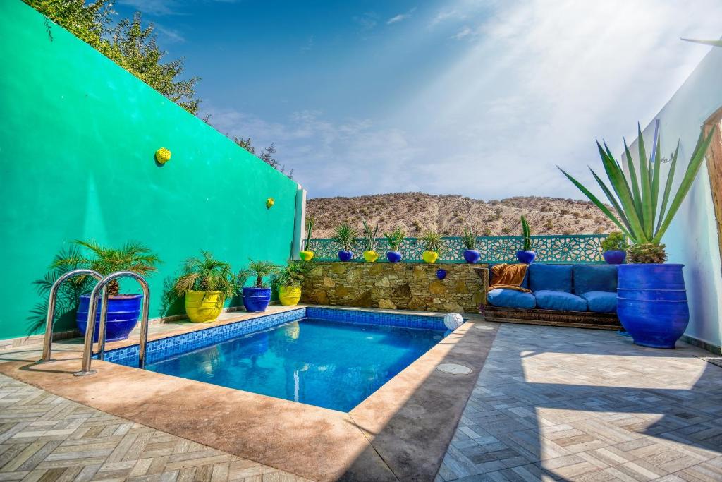 una piscina en un patio con plantas y una pared verde en Route de miel, en Agadir