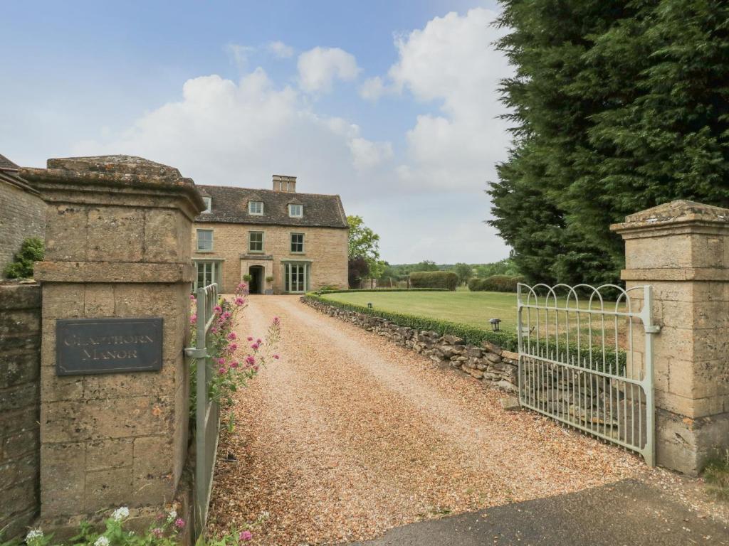 an entrance to a stone house with a gate at Glapthorn Manor in Peterborough