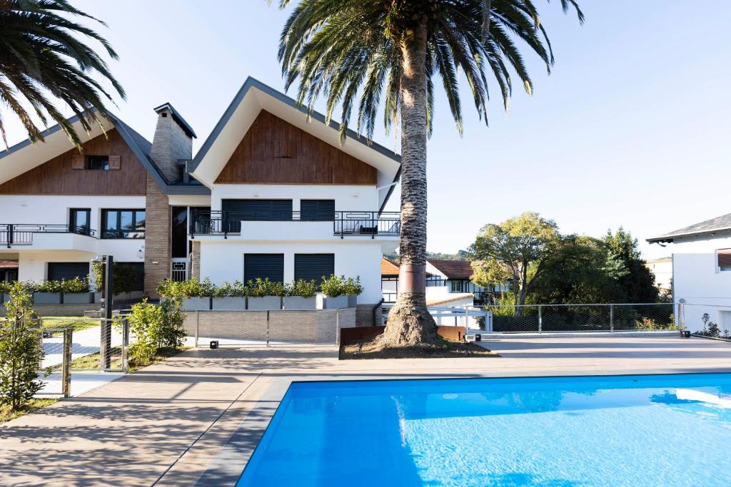 a villa with a swimming pool in front of a house at Kofradia in Hondarribia