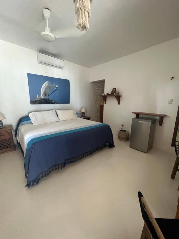 a bedroom with a large bed with a blue blanket at Casa Tom Tom in Holbox Island