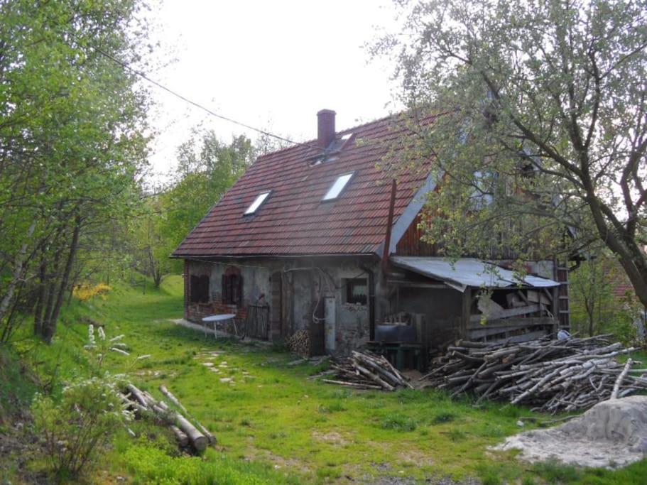 una casa vieja sentada en medio de un campo en Animal Farm - agroturystyka konik polski, en Przecznica