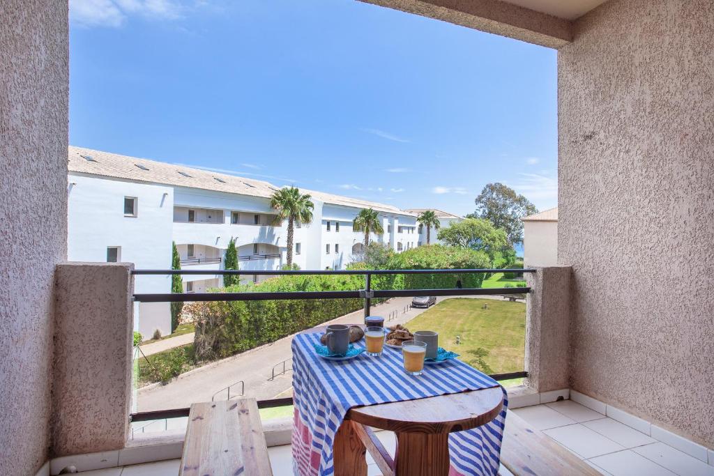 - une table sur un balcon avec vue sur un bâtiment dans l'établissement Casa Les Marines, à San-Nicolao