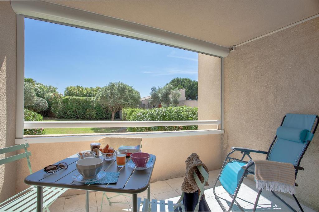 un balcon avec une table et des chaises et une grande fenêtre dans l'établissement Casa Maria Beach, à Santa-Lucia-di-Moriani