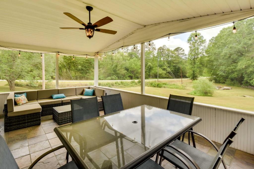 a screened porch with a ceiling fan and a table and chairs at Georgia Vacation Rental with Covered Deck and Patio in Dahlonega