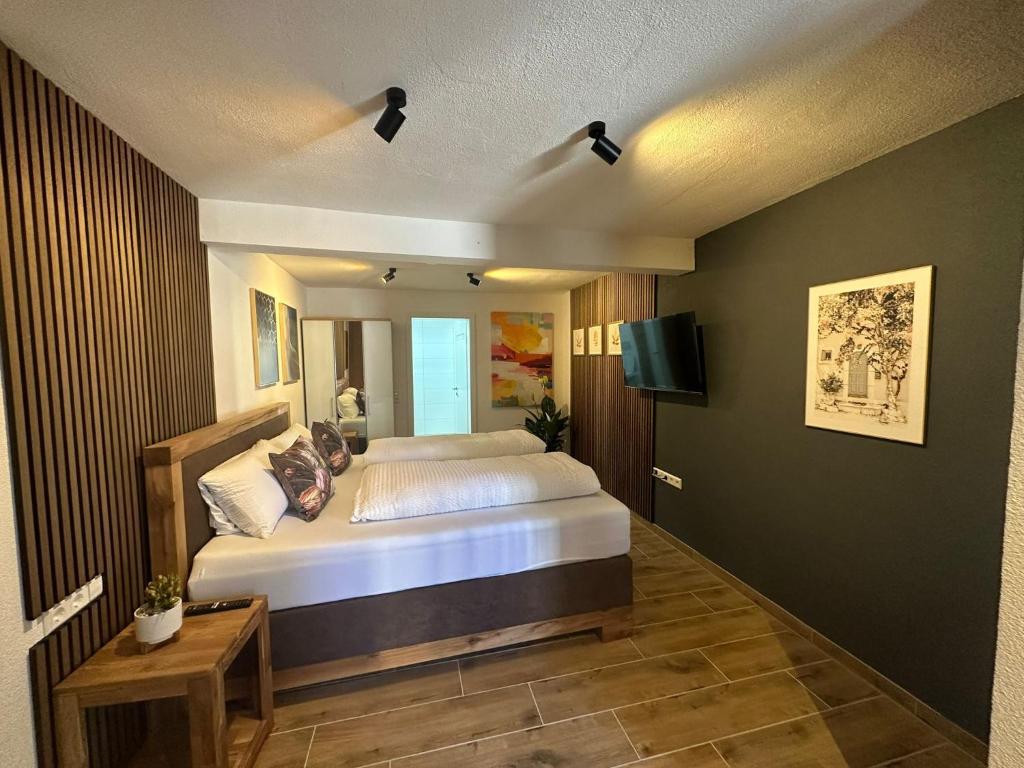 a bedroom with a bed and a flat screen tv at Gasthaus zu den 7 Winden in Spaichingen
