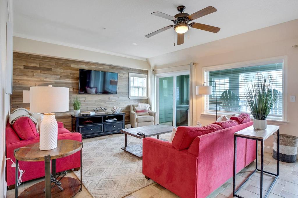 a living room with red furniture and a ceiling fan at FFR101 - The Wright Idea in Kill Devil Hills