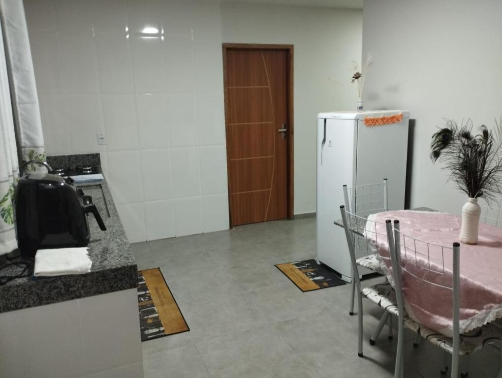 a living room with a table and a refrigerator at Residencial Casa Grande - Apto 02 in Santa Cruz Cabrália