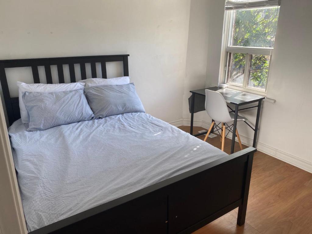 a bedroom with a bed and a desk and a window at Private Double Room with Shared Bathroom 536B in Toronto