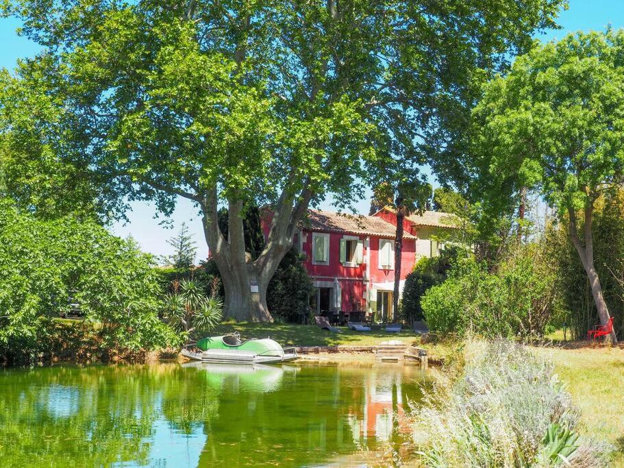 un bateau dans l'eau devant une maison dans l'établissement Mas de la Villardière, à Raphèle