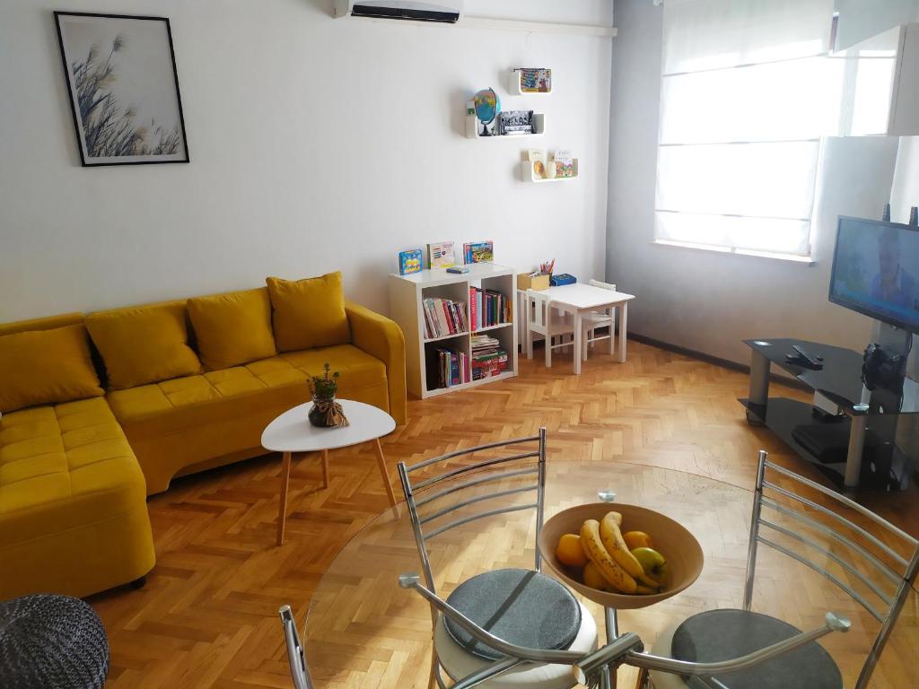 a living room with a yellow couch and a table at Superior Familiy Apartment Tina in Vrsar