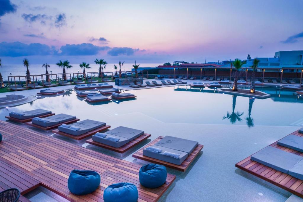 - une grande piscine avec chaises longues dans l'établissement SENSEANA Sea Side Resort & Aquadventure, à Chersónissos