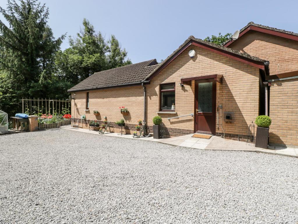 une maison avec une allée en gravier en face de celle-ci dans l'établissement Swn Y Nant, à Tondu