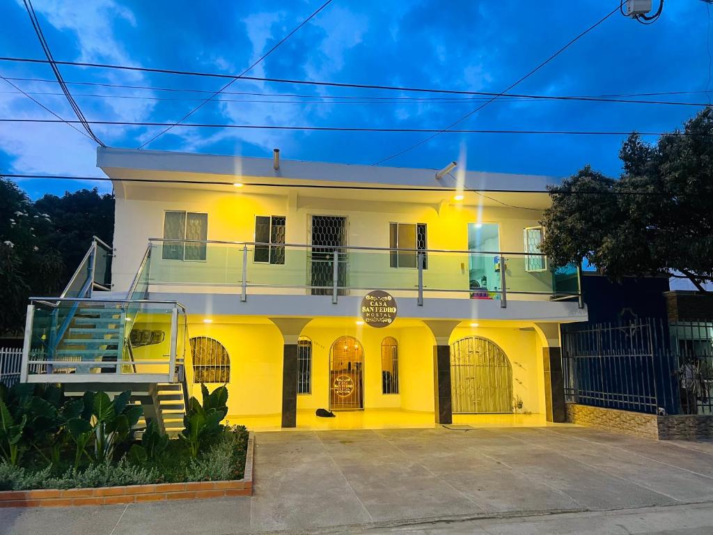 een groot wit huis met een oprit ervoor bij Hostal Casa San Pedro in Santa Marta