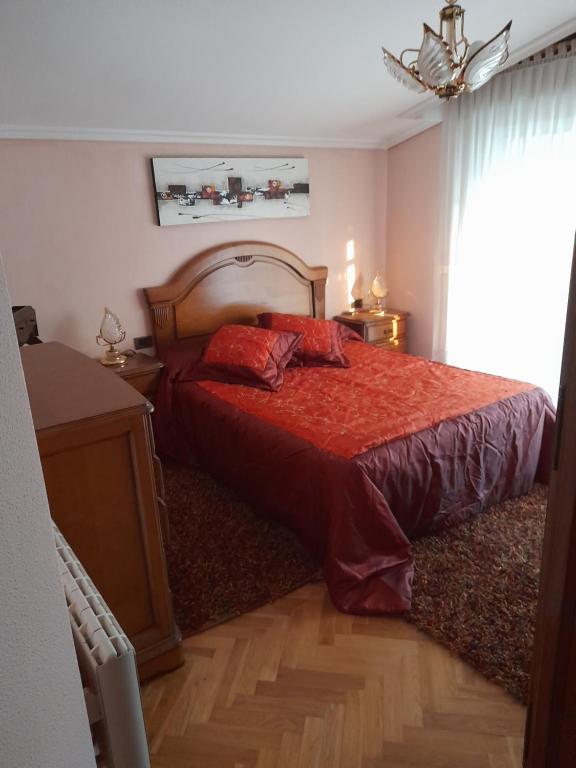 1 dormitorio con 1 cama con edredón rojo en Atico augaboa, en Cangas de Morrazo