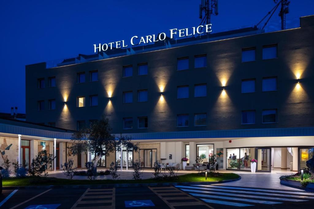 una rappresentazione del palazzo dell'hotel Carolina di notte di Hotel Carlo Felice a Sassari