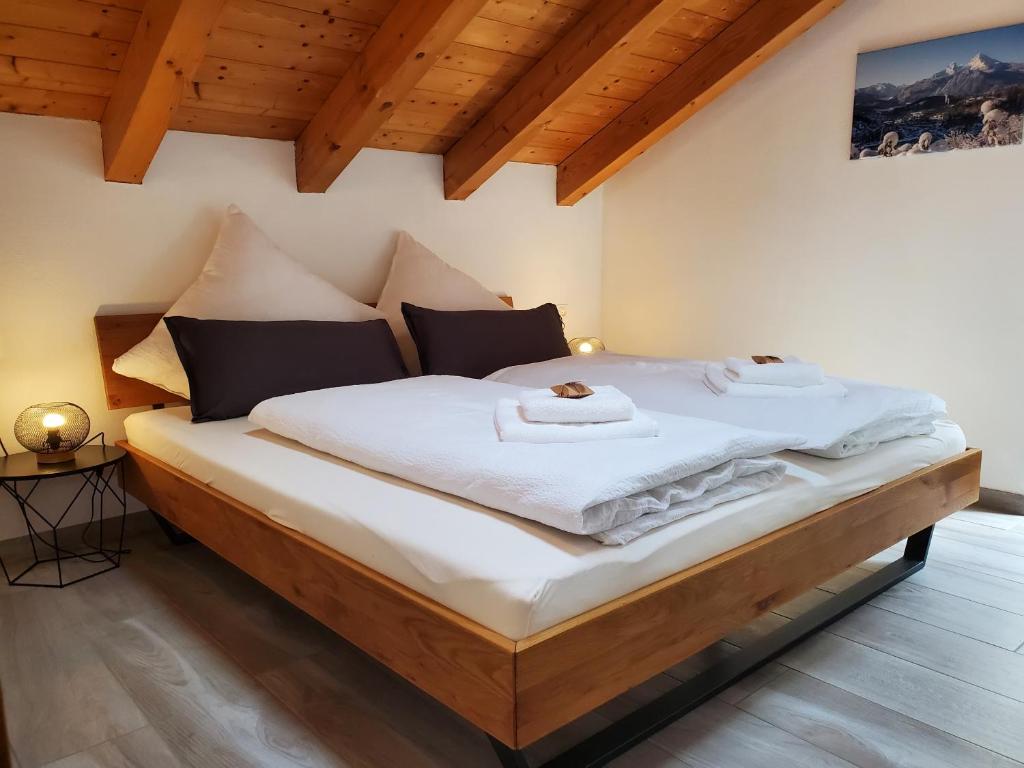 duże łóżko w pokoju z drewnianymi sufitami w obiekcie Ferienwohnung Gipfelstürmer w mieście Berchtesgaden