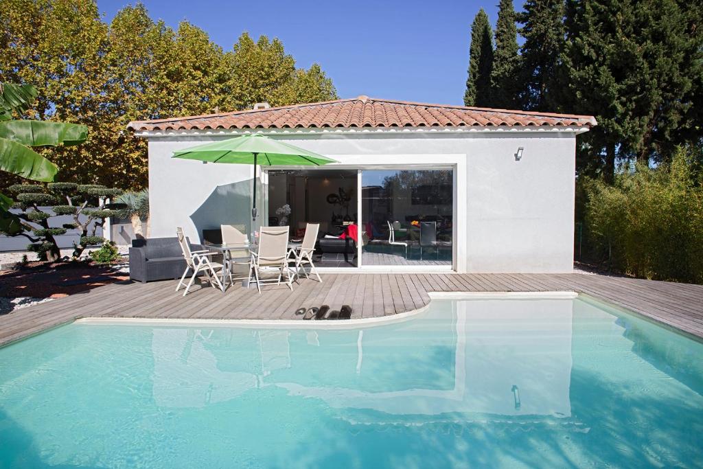 ein Haus mit einem Pool und einer Terrasse mit einem Sonnenschirm in der Unterkunft Belle Villa moderne avec piscine et jardin in Solliès-Pont
