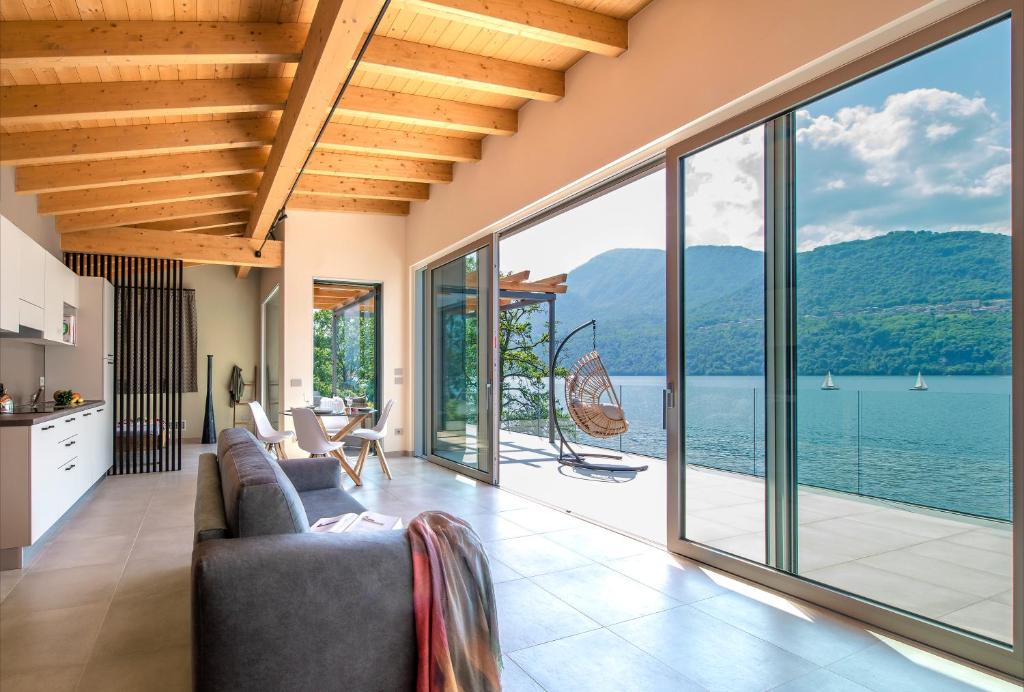 a living room with a view of the water at d'Ocalée Holiday Experience lago d'Orta in Omegna