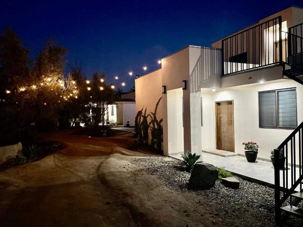 een groot wit huis met verlichting in de nacht bij Villa Macrina in Valle de Guadalupe