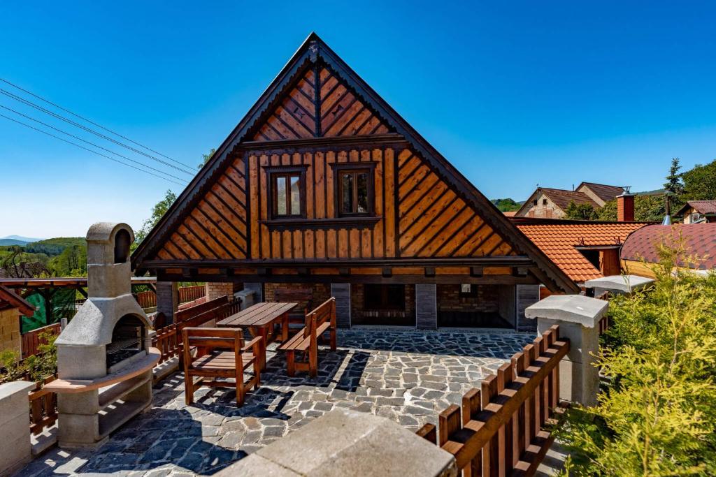 une maison avec un toit en bois et un patio en pierre dans l'établissement Apartmány Třebušín, 