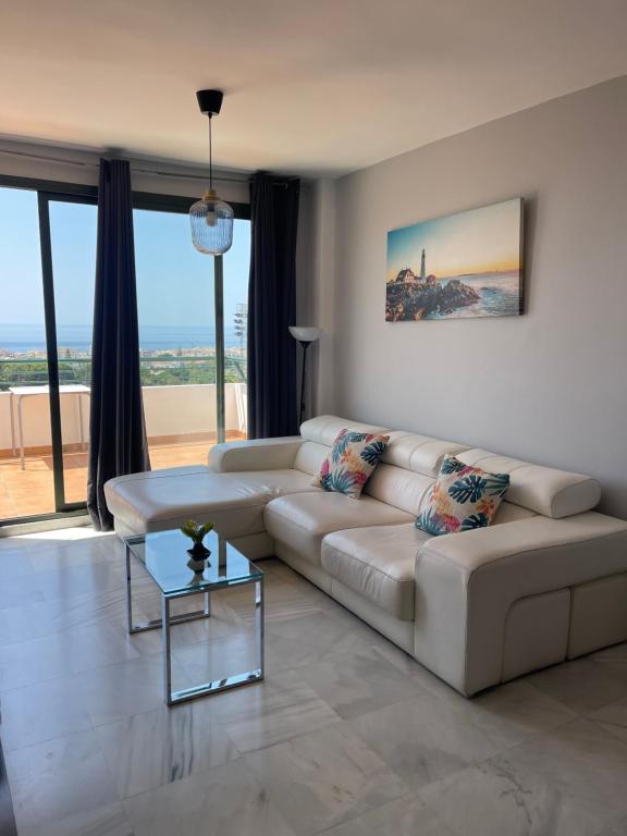 uma sala de estar com um sofá e uma mesa em Apartamento en Nerja con vistas al Mar. em Nerja