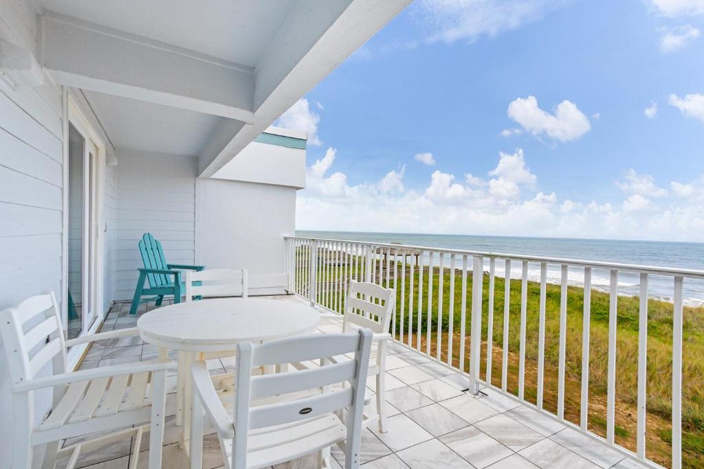 a balcony with a table and chairs and the ocean at JY422 - John Yancey Oceanfront Inn Penthouse Suite in Kill Devil Hills